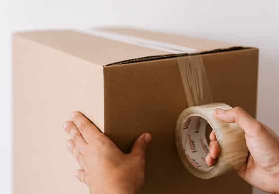 Cardboard Box Being Sealed With Packing Tape