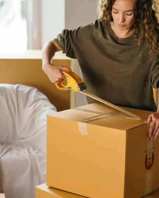 Woman packing a box for a move on the Sunshine Coast
