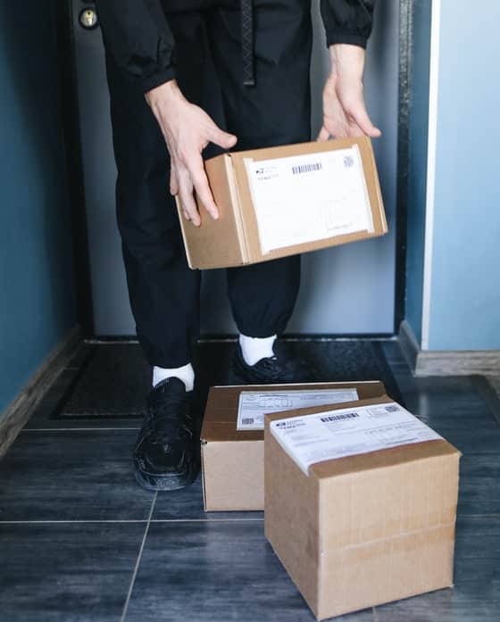 Man Picking Up Cardboard Box — Caloundra Removals & Storage in Sunshine Coast, QLD