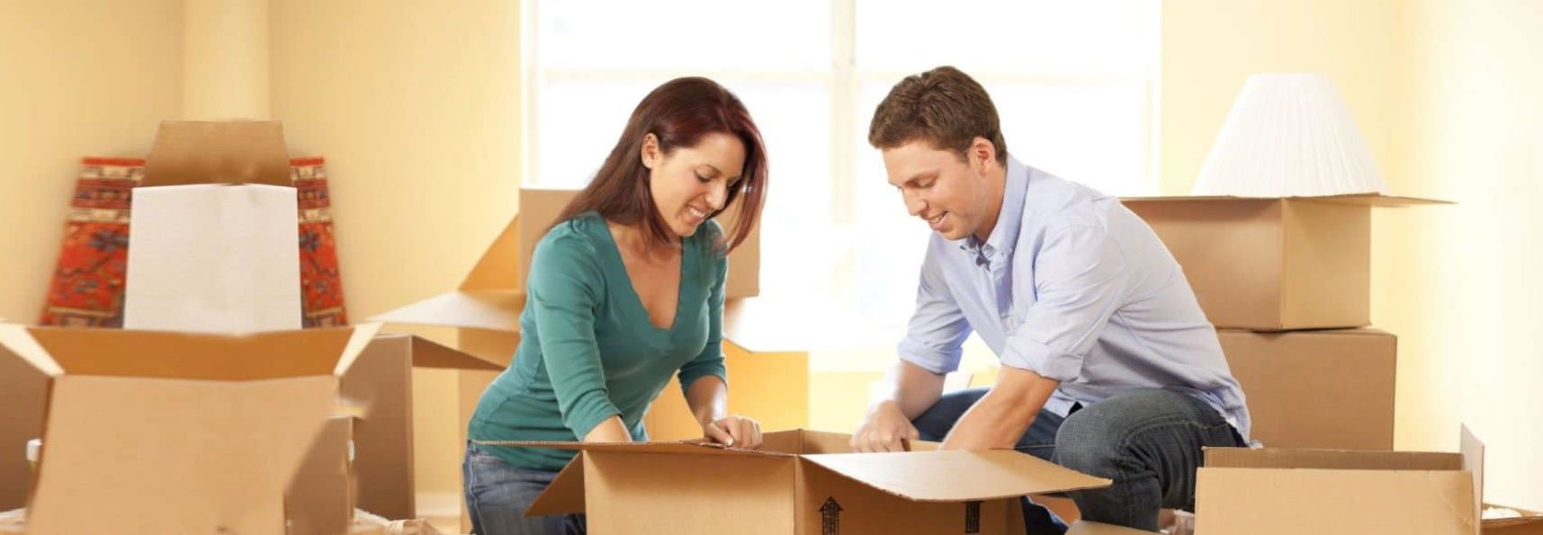 Smiling Couple Unpacking Boxes After Moving — Caloundra Removals & Storage in Sunshine Coast, QLD