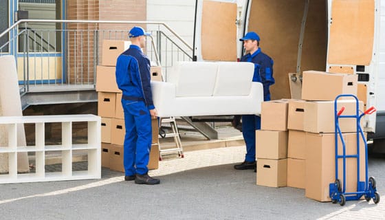 Workers Lifting a White Couch Into a Removals Truck