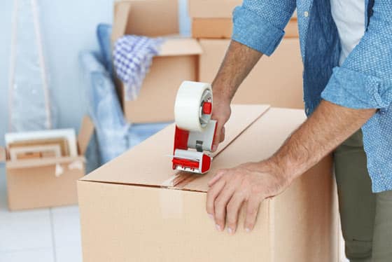 Man Adding Tape To The Moving Box — Caloundra Removals & Storage in Warana, QLD