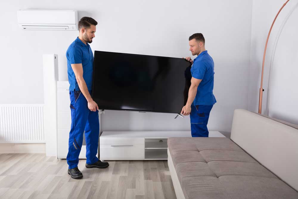 Two Male Mover Removing a TV From The Table