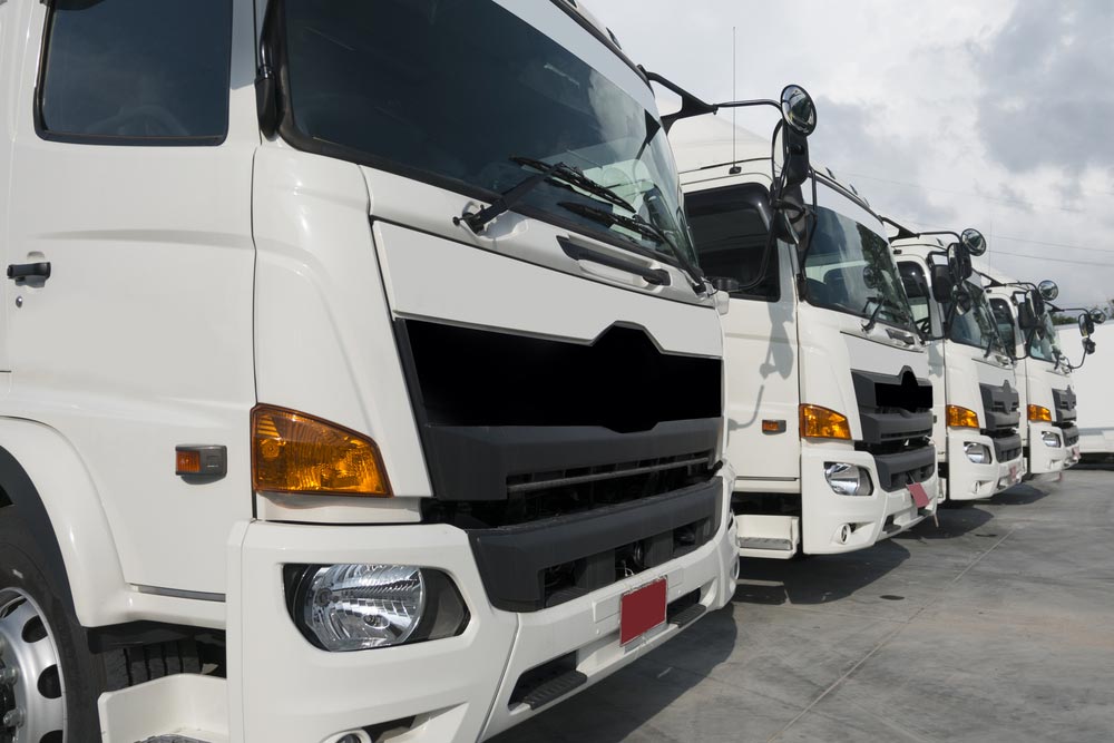 A Fleet Of White Moving Trucks