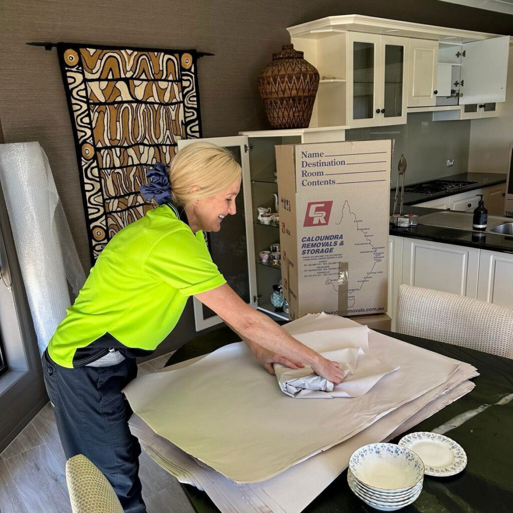 Woman Packing Plates Properly For Moving — Caloundra Removals & Storage in Sunshine Coast, QLD